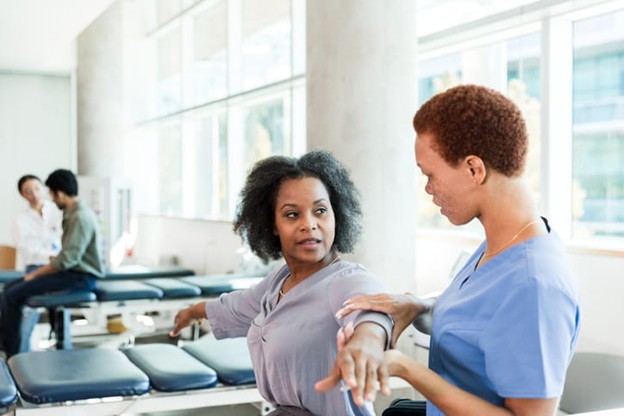 A physical therapist works with a patient.
