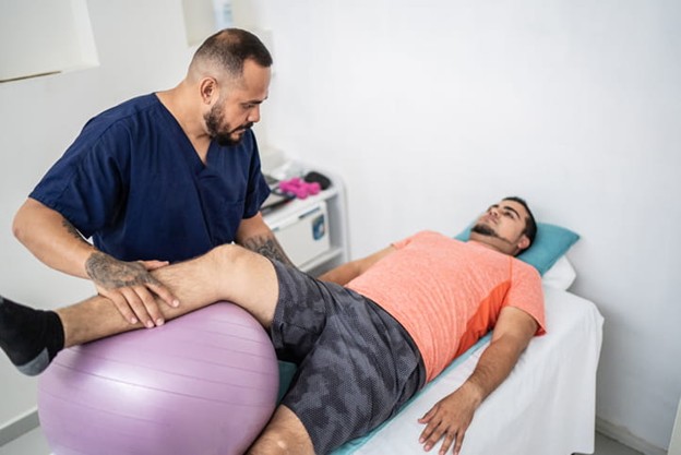 A physical therapist assisting a patient after a hip fracture.