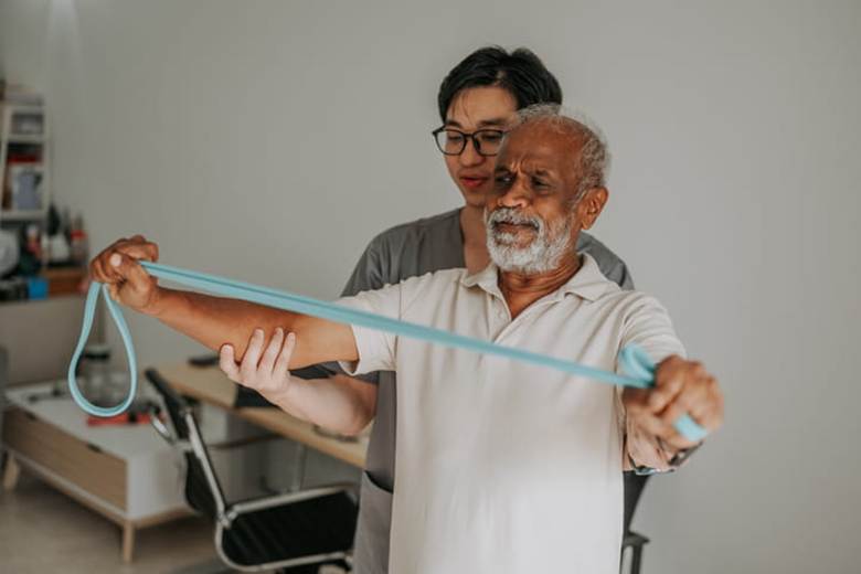 A physical therapist assists a patient.