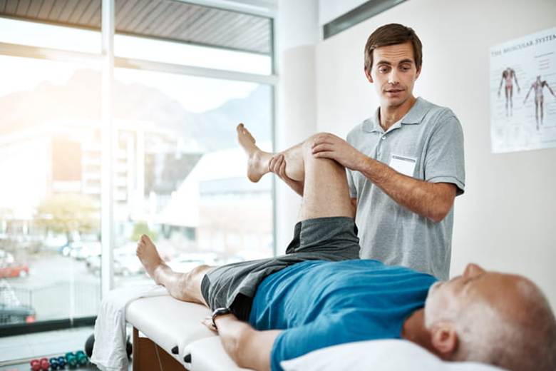 A physical therapist working with a patient who has an injured knee.