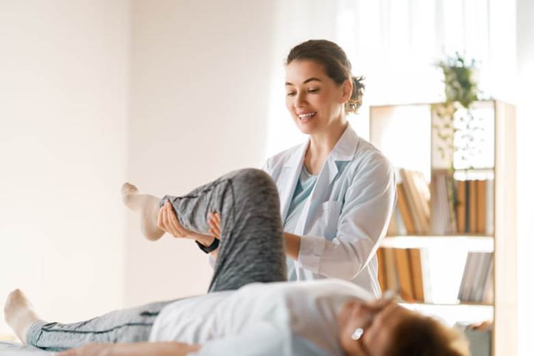 A physical therapist assists a patient after a work-related injury.