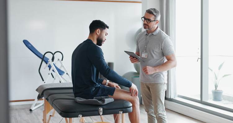 A physical therapist discusses a treatment plan with a patient.