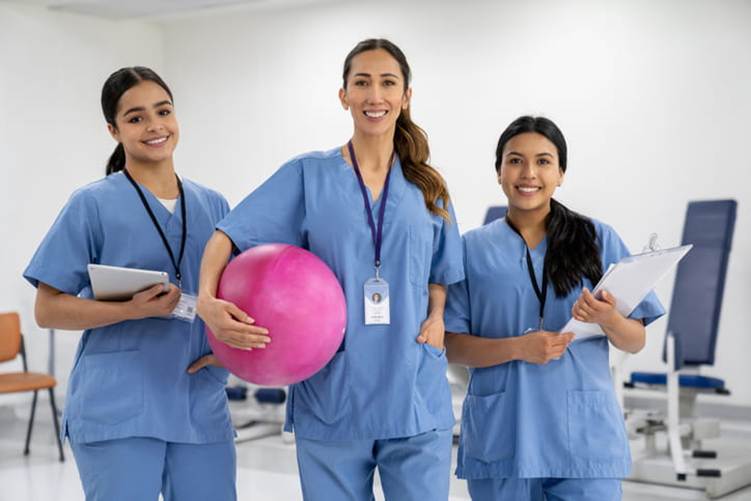 Three physical therapists smile together.